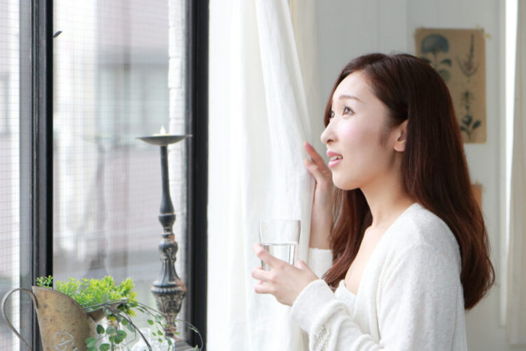 woman closing curtain