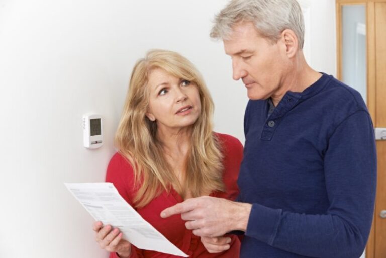 an older couple looking at bills