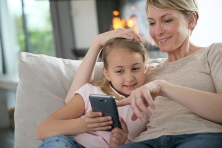 mom and daughter looking at smartphone
