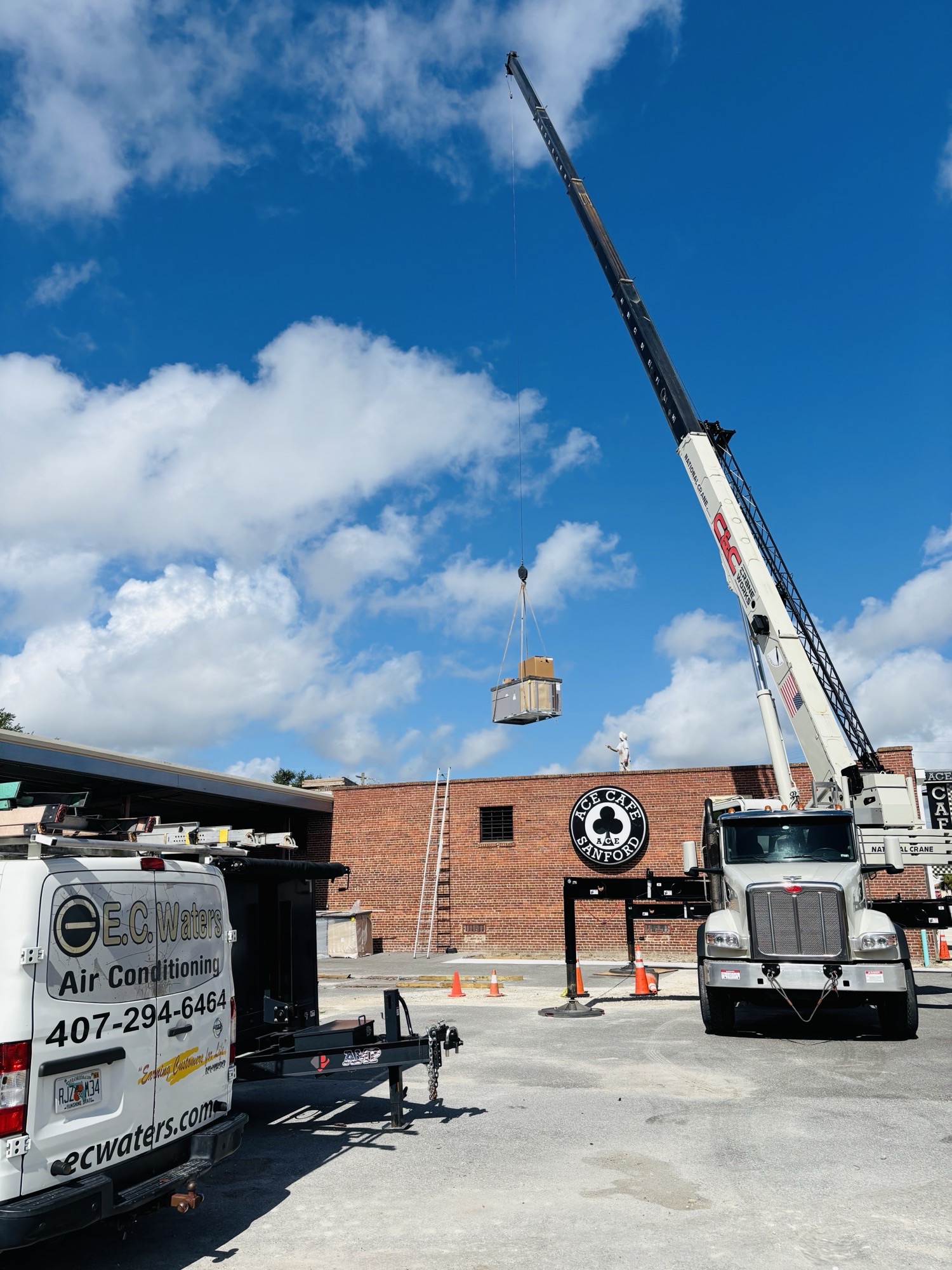 AC unit lifted by crane - with branded van